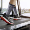 Male feet in sneakers running on the treadmill at the gym. Exerc