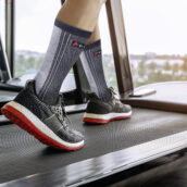 Male feet in sneakers running on the treadmill at the gym. Exerc