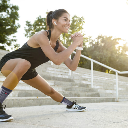 Portrait of a smiling fitness woman in earphones